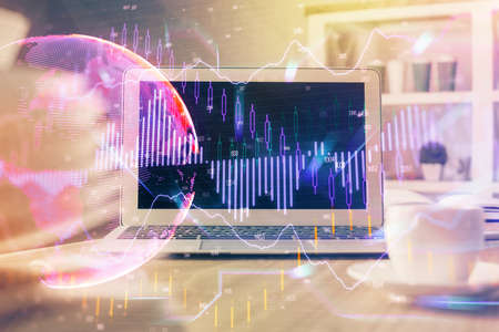 Forex market graph hologram and personal computer on background. Double exposure. Concept of...