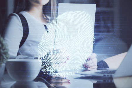 Blue fingerprint hologram over woman's hands taking notes background. Concept of protection. Double...