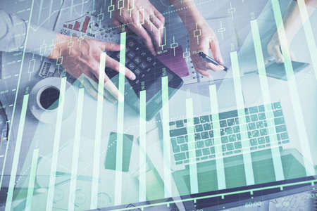 Double exposure of man and woman working together and financial chart hologram drawing. market...