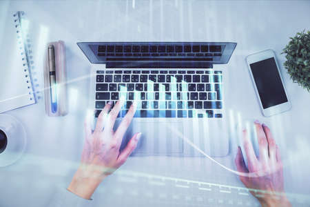 Double exposure of woman hands working on computer and forex chart hologram drawing. Top View....