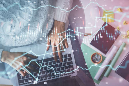 Multi exposure of woman hands working on computer and forex chart hologram drawing. Top View....