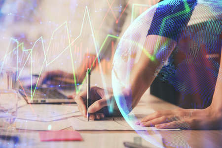 Multi exposure of woman hands typing on computer and financial chart hologram drawing. Stock market...