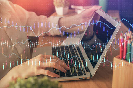 Double exposure of woman hands typing on computer and forex chart hologram drawing. Stock market...