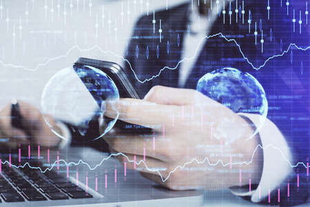 Multi exposure of man's hands holding and using a digital phone and forex graph drawing. Financial...