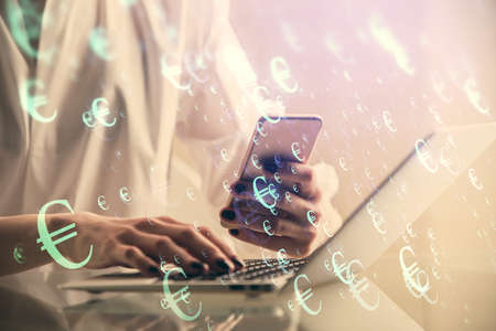 Double exposure of financial graph sketch hologram and woman holding and using a mobile device....
