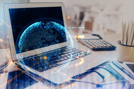 Double exposure of desktop with computer and world map hologram. International data network concept.の写真素材
