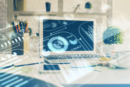 Computer on desktop in office with technology theme hologram. Double exposure. Tech concept.