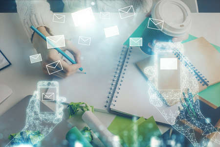 E-mail abstract envelop drawing over hands taking notes background. Concept of electronic mail. Double exposureの写真素材