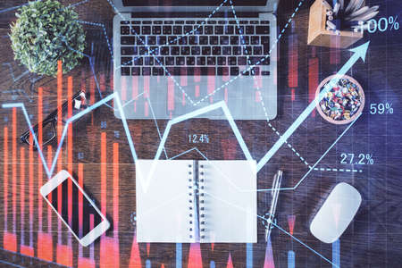 Stock market graph and top view computer on the table background. Double exposure. Concept of financial education.の写真素材