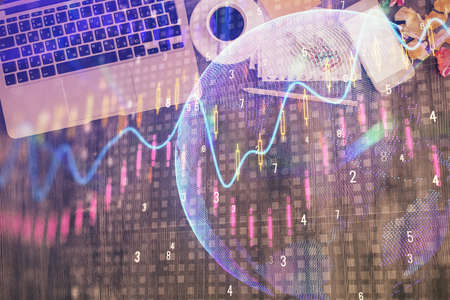 Financial market graph and top view computer on the desktop background. Double exposure. Investment...