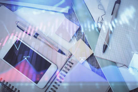 Multi exposure of forex graph hologram over desktop with phone. Top view. Mobile trade platform...
