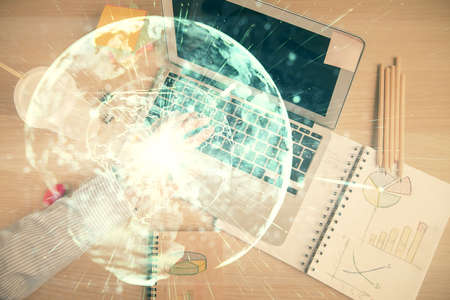 Double exposure of man's hands typing over computer keyboard and business theme hologram drawing....