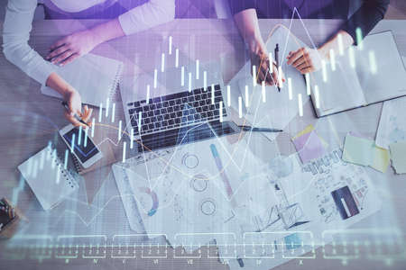 Double exposure of woman hands working on computer and forex graph hologram drawing. Top View....