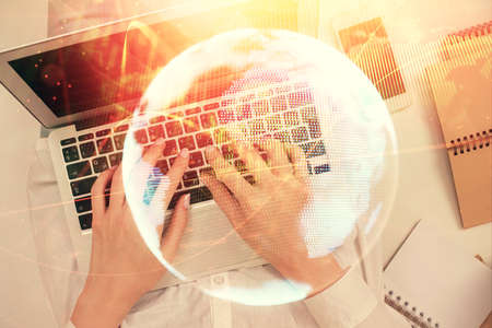 Double exposure of woman hands working on computer and financial theme hologram drawing. Top View....