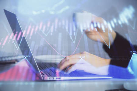 Double exposure of businesswoman hands typing on computer and forex graph hologram drawing. Financial analysis concept.の写真素材