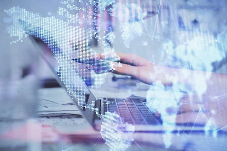 Multi exposure of woman hands typing on computer and financial graph hologram drawing. Stock market...