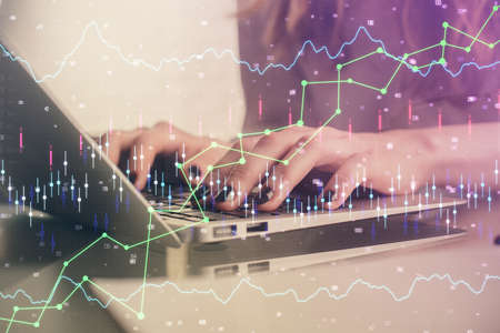 Double exposure of woman hands typing on computer and forex chart hologram drawing. Stock market...