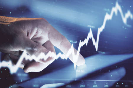 Multi exposure of man's hands holding and using a phone and financial chart drawing. Market analysis...
