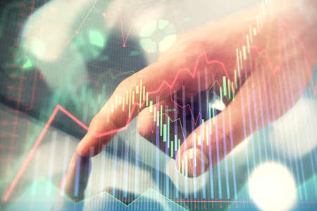 Multi exposure of man's hands holding and using a phone and financial chart drawing. Market analysis...