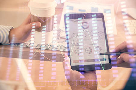 Double exposure of man's hands holding and using a phone and financial chart drawing. Market...