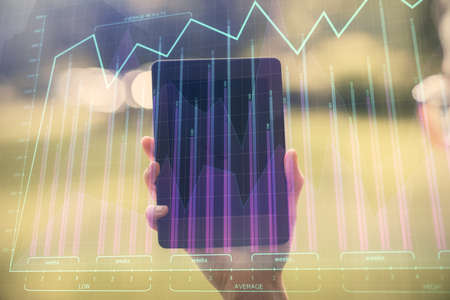 Double exposure of forex chart sketch hologram and woman holding and using a mobile device....