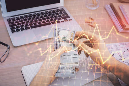 Multi exposure of financial graph drawing hologram and USA dollars bills and man hands. Analysis...