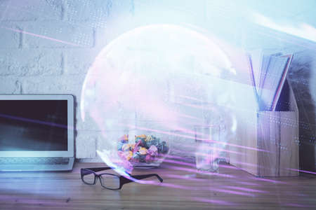 Computer on desktop in office with technology theme hologram. Double exposure. Tech concept.