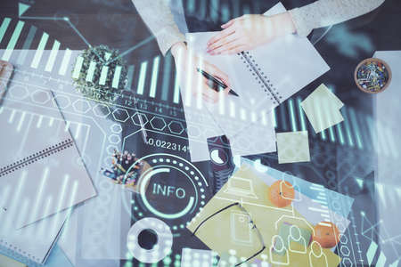 Technology theme hologram over woman's hands taking notes background. Concept of Tech. Double exposureの写真素材