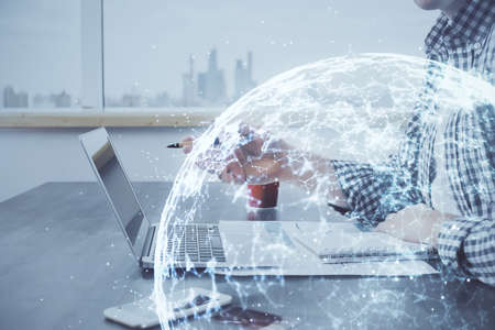 Social network theme hologram with businessman working on computer on background. Concept of world...