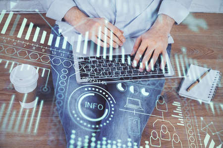 Technology theme hologram with man working on computer on background. High tech concept. Multi...