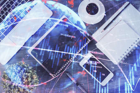 Double exposure of forex chart hologram over desktop with phone. Top view. Mobile trade platform concept.の写真素材