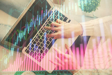 Double exposure of woman hands working on computer and forex chart hologram drawing. Top View....