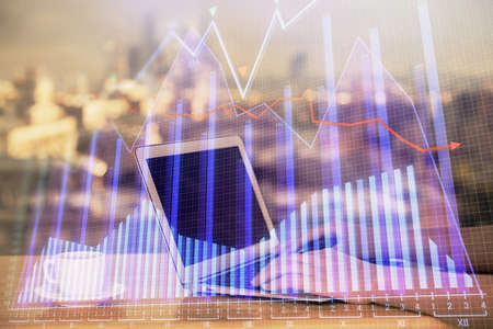 Double exposure of businesswoman hands typing on computer and forex chart hologram drawing....