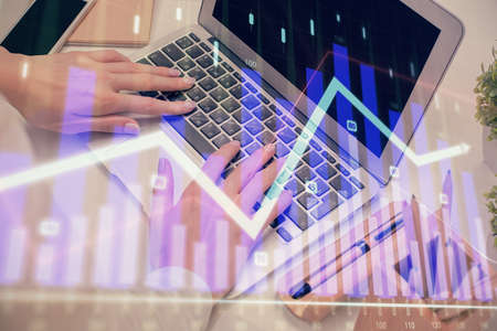 Multi exposure of woman hands typing on computer and forex chart hologram drawing. Stock market...