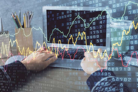 Double exposure of woman hands typing on computer and forex chart hologram drawing. Stock market...