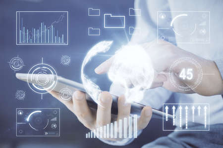 Double exposure of man's hands holding and using a digital device and forex graph drawing. Financial...