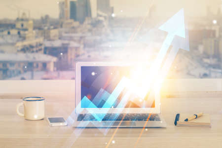 Computer on desktop with point up arrows hologram. Double exposure. Concept of success.の写真素材