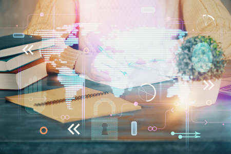 Double exposure of hands making notes with world map hologram and data theme icons. Concept of...
