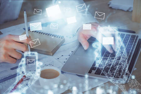 Envelop holograms with businessman working on computer on background. E-mail concept. Multi...