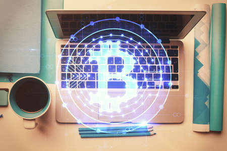 Blockchain theme hologram drawings over computer on the desktop background. Top view. Multi...