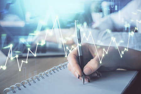Double exposure of forex chart drawing over people taking notes background. Concept of financial...