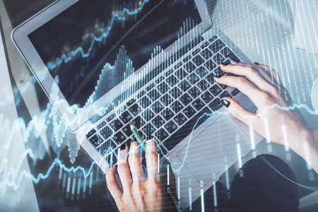 Double exposure of woman hands working on computer and forex chart hologram drawing. Top View. Financial analysis concept.の写真素材