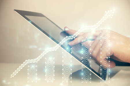 Multi exposure of man's hands holding and using a digital phone and forex graph drawing. Financial...