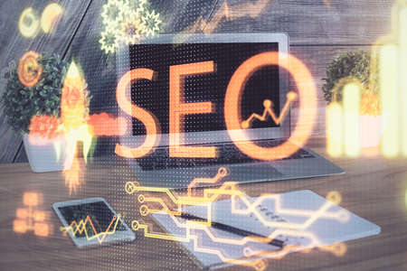 Multi exposure of table with computer and seo drawing hologram. Search optimization concept.