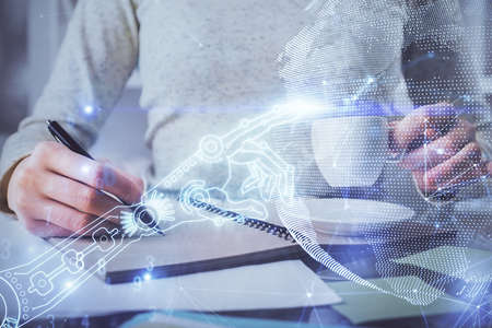 Tech theme hologram over woman's hands taking notes background. Concept of hightech. Double exposure
