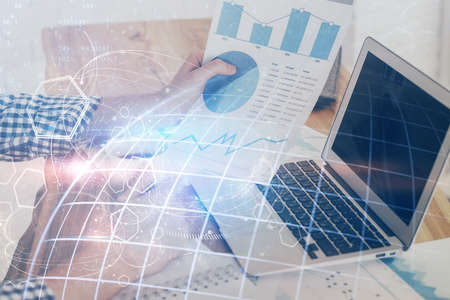Double exposure of world map hologram with man working on computer on background. Concept of...