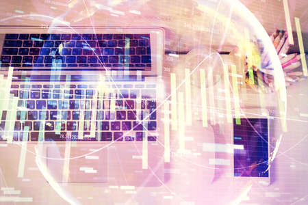 Business theme hologram drawings over computer on the desktop background. Top view. Multi exposure....