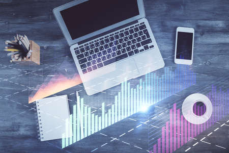 Double exposure of forex chart drawing over table background with computer. Concept of financial...