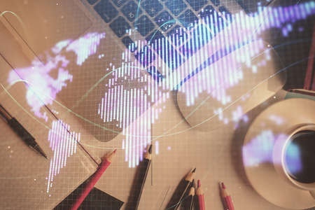 Business theme hologram drawings over computer on the desktop background. Top view. Multi exposure....