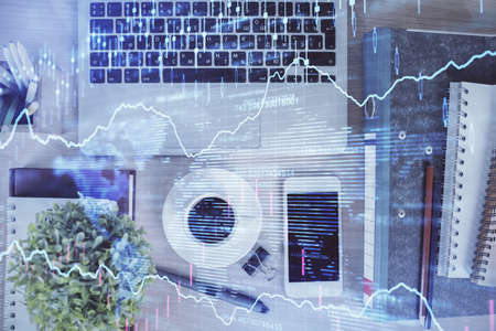 Double exposure of financial graph hologram over desktop with phone. Top view. Mobile trade platform...